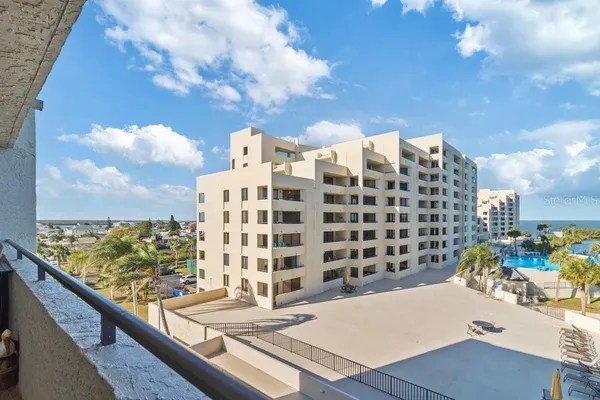 a front view of a house with a garden and trees
