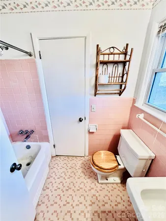 a white toilet sitting next to a bathroom sink and a tub