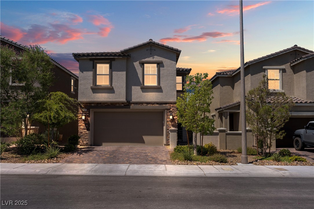 8099 Rams Collide Street Las Vegas, NV 89166 - Photo 1 of 72 Mediterranean / spanish-style home with a tiled roof, stone siding, stucco siding, decorative driveway, and an attached garage