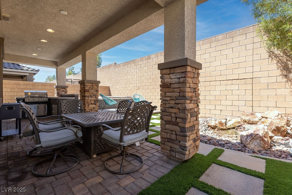 8099 Rams Collide Street Las Vegas, NV 89166 - Photo 16 of 72 Fenced backyard with a patio area, outdoor dining space, built-in grill and jacuzzi with step up deck