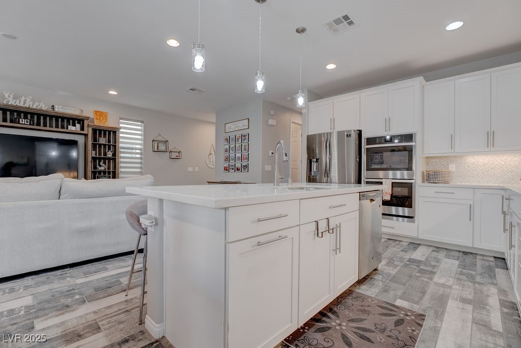 8099 Rams Collide Street Las Vegas, NV 89166 - Photo 72 of 72 Kitchen with decorative backsplash, white cabinetry, open floor plan, hanging light fixtures, and recessed lighting