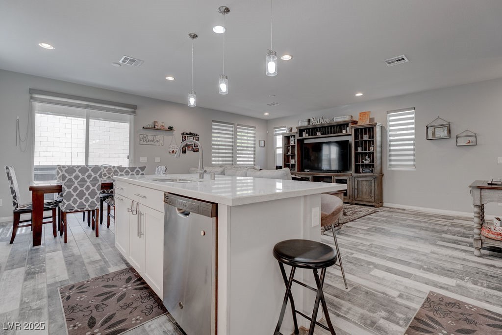 8099 Rams Collide Street Las Vegas, NV 89166 - Photo 22 of 72 Kitchen with a kitchen bar, dishwasher, hanging light fixtures, an island with sink, and plenty of natural light