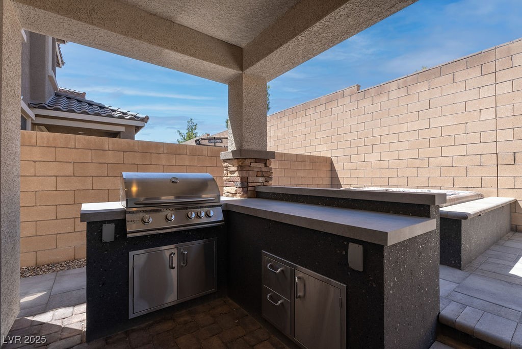 8099 Rams Collide Street Las Vegas, NV 89166 - Photo 26 of 72 Fenced backyard with an outdoor kitchen and a patio area