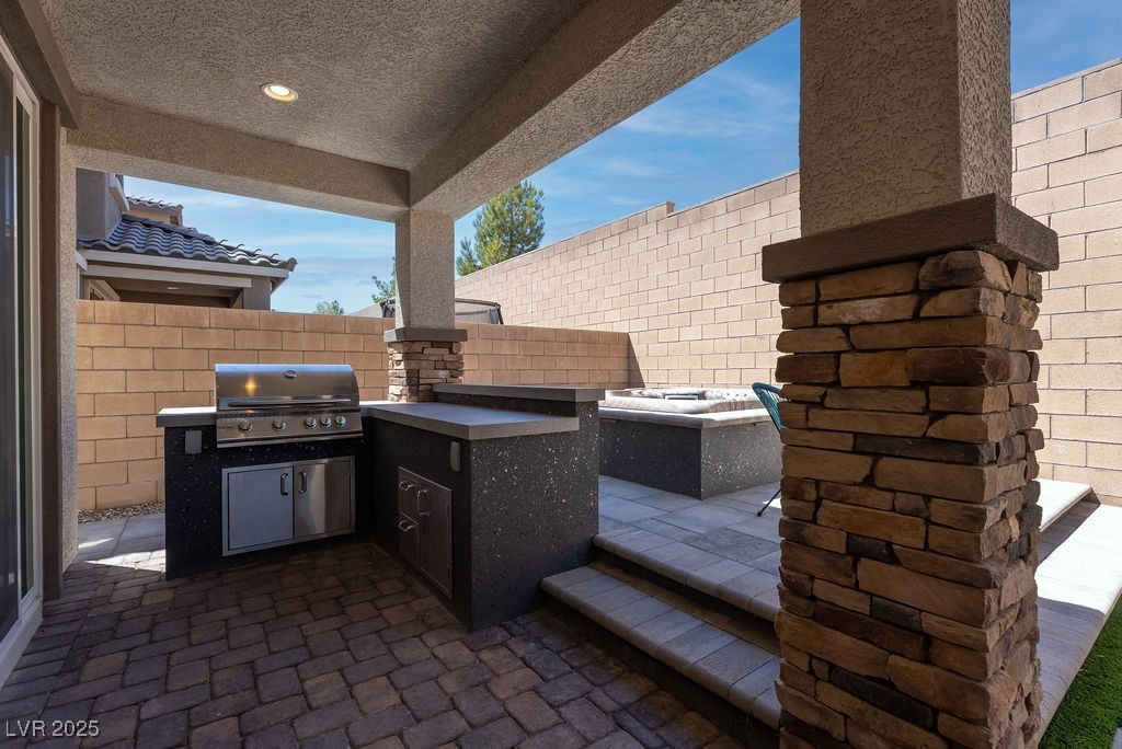 8099 Rams Collide Street Las Vegas, NV 89166 - Photo 27 of 72 Fenced backyard with an outdoor kitchen and a patio area