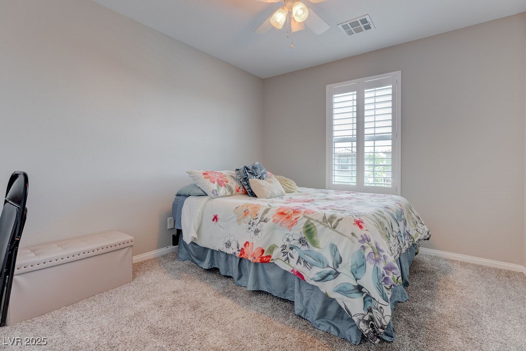 8099 Rams Collide Street Las Vegas, NV 89166 - Photo 35 of 72 Bedroom with light colored carpet and ceiling fan
