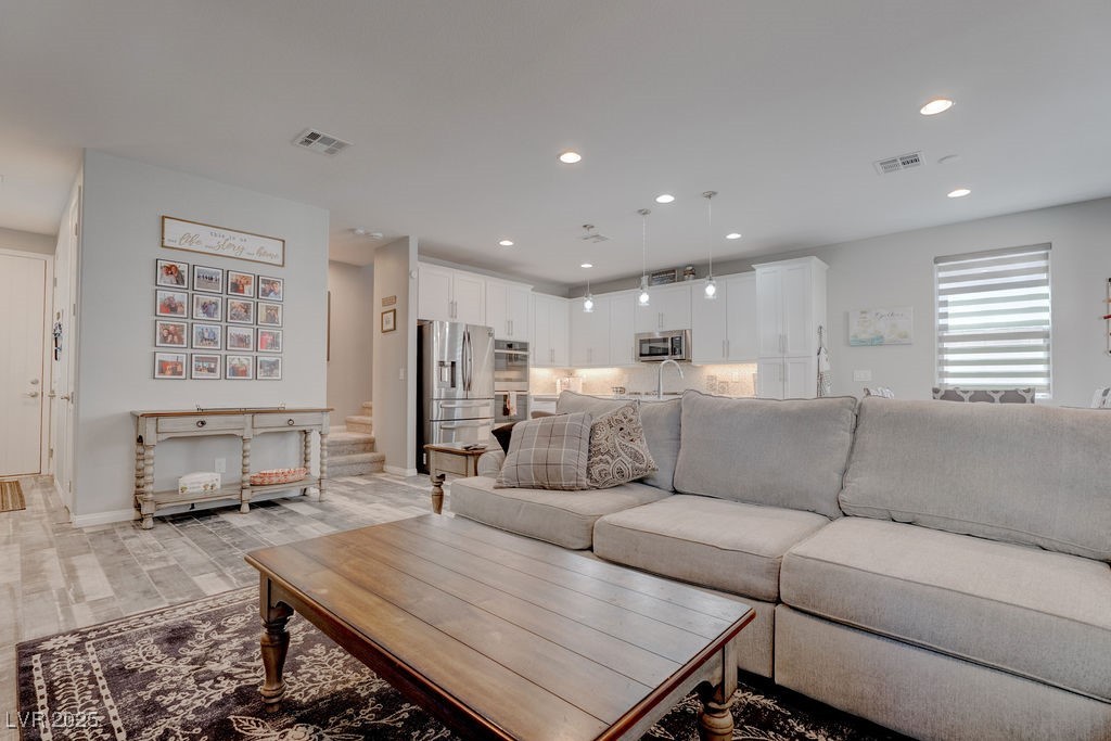 8099 Rams Collide Street Las Vegas, NV 89166 - Photo 5 of 72 Living area featuring recessed lighting, light wood finished floors, and stairs