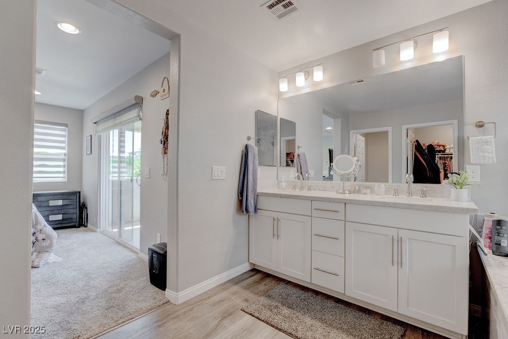 8099 Rams Collide Street Las Vegas, NV 89166 - Photo 52 of 72 Bathroom with double vanity, light wood-style flooring, recessed lighting, and a spacious closet