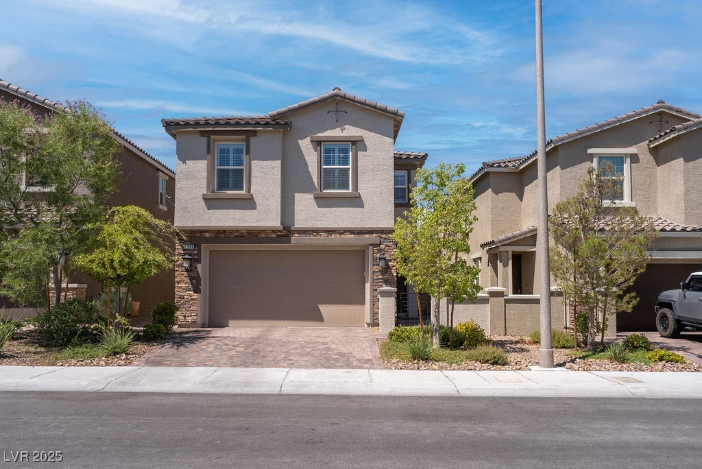 8099 Rams Collide Street Las Vegas, NV 89166 - Photo 66 of 72 Mediterranean / spanish house featuring stone siding, an attached garage, driveway, and stucco siding