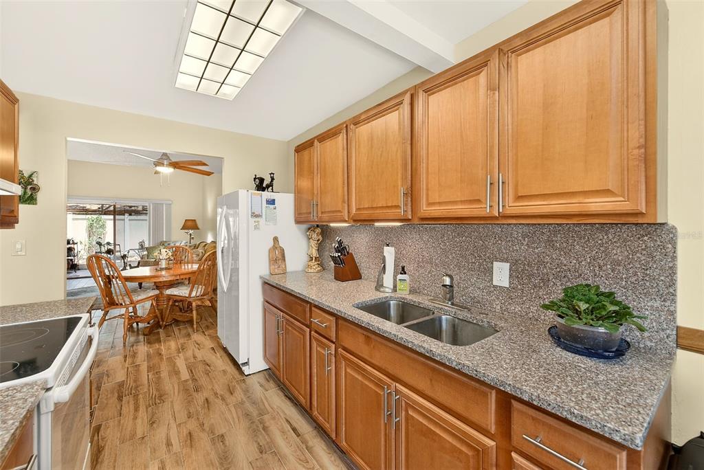 2064 Sunset Point Road, Unit 73 Clearwater, FL 33765 - Photo 19 of 58 a kitchen with stainless steel appliances granite countertop a sink a stove and cabinets
