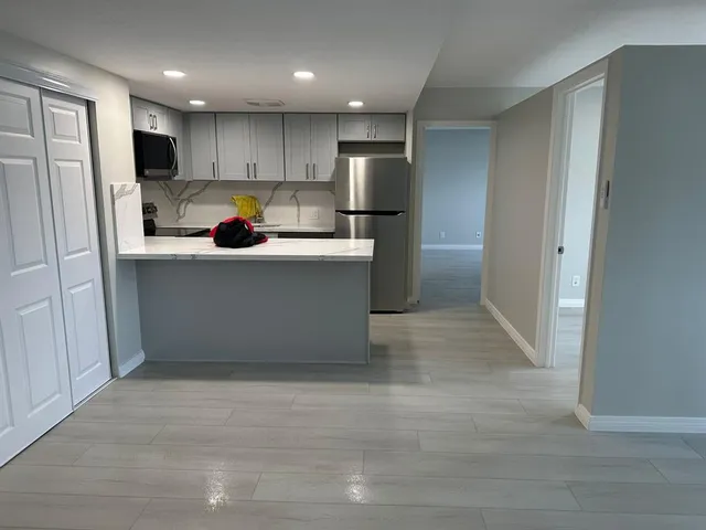 a kitchen with white cabinets and stainless steel appliances