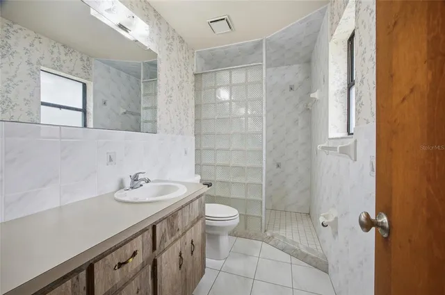 a bathroom with a sink a toilet and shower