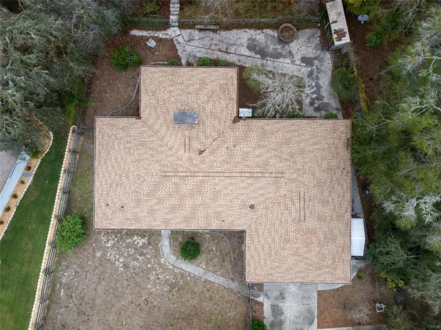 an aerial view of a house with a yard and lake view