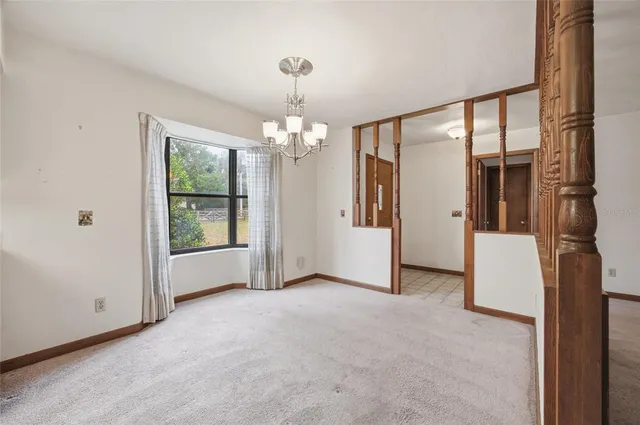 a view of a big room with windows and chandelier