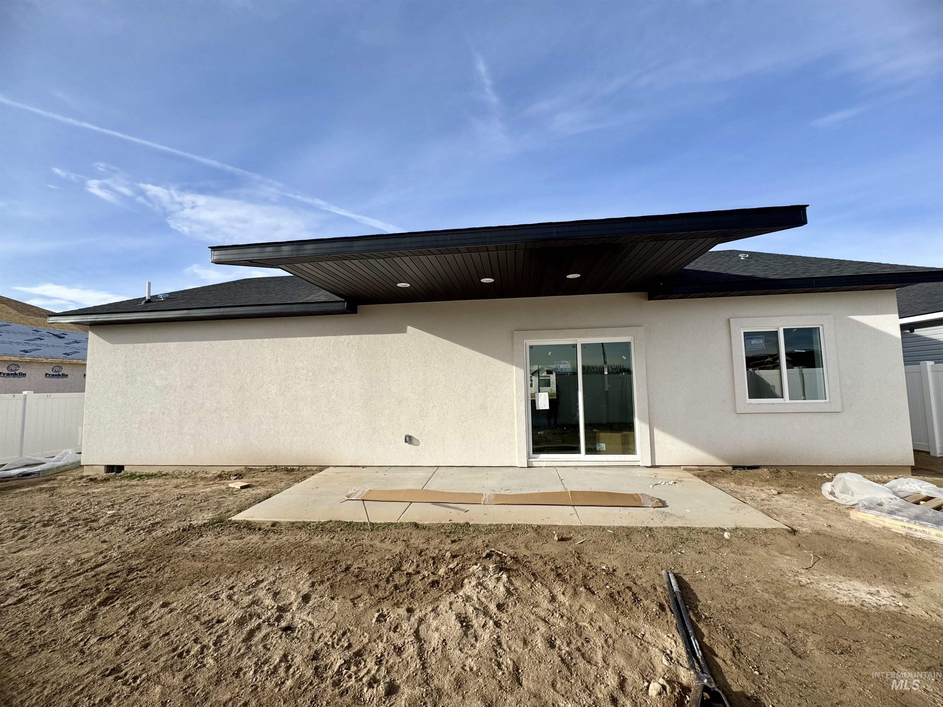 2014 Regan Street Jerome, ID 83338 - Photo 2 of 15 Rear view of house featuring a patio area, stucco siding, and roof with shingles