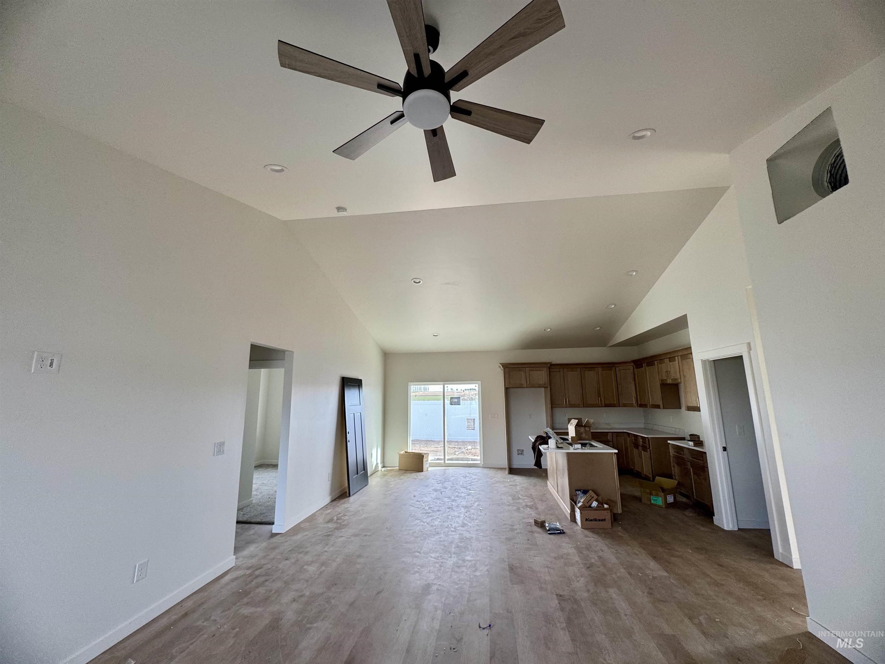 2014 Regan Street Jerome, ID 83338 - Photo 4 of 15 Unfurnished living room with high vaulted ceiling, wood finished floors, and a ceiling fan