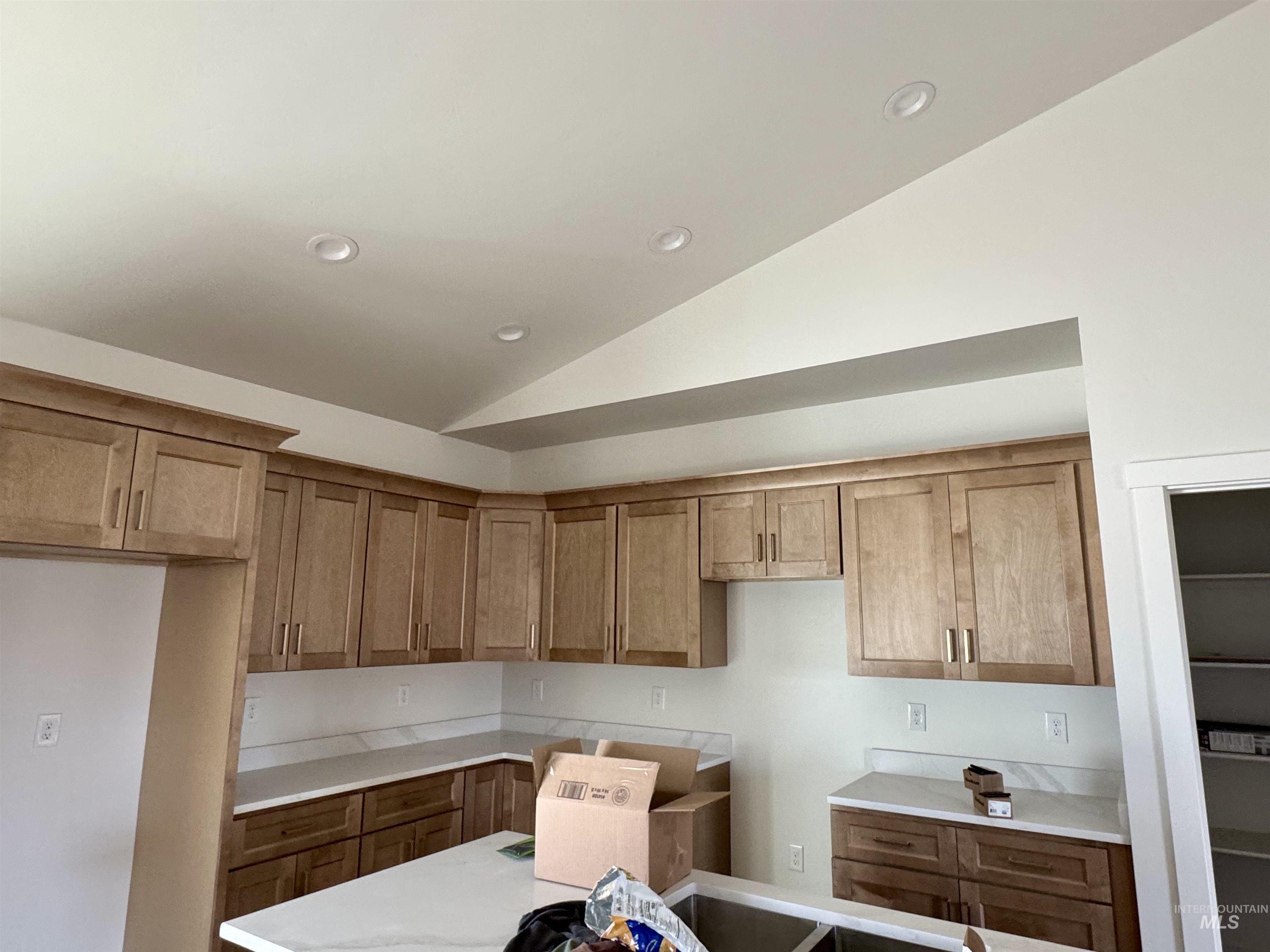 2014 Regan Street Jerome, ID 83338 - Photo 6 of 15 Kitchen featuring brown cabinetry, lofted ceiling, and recessed lighting