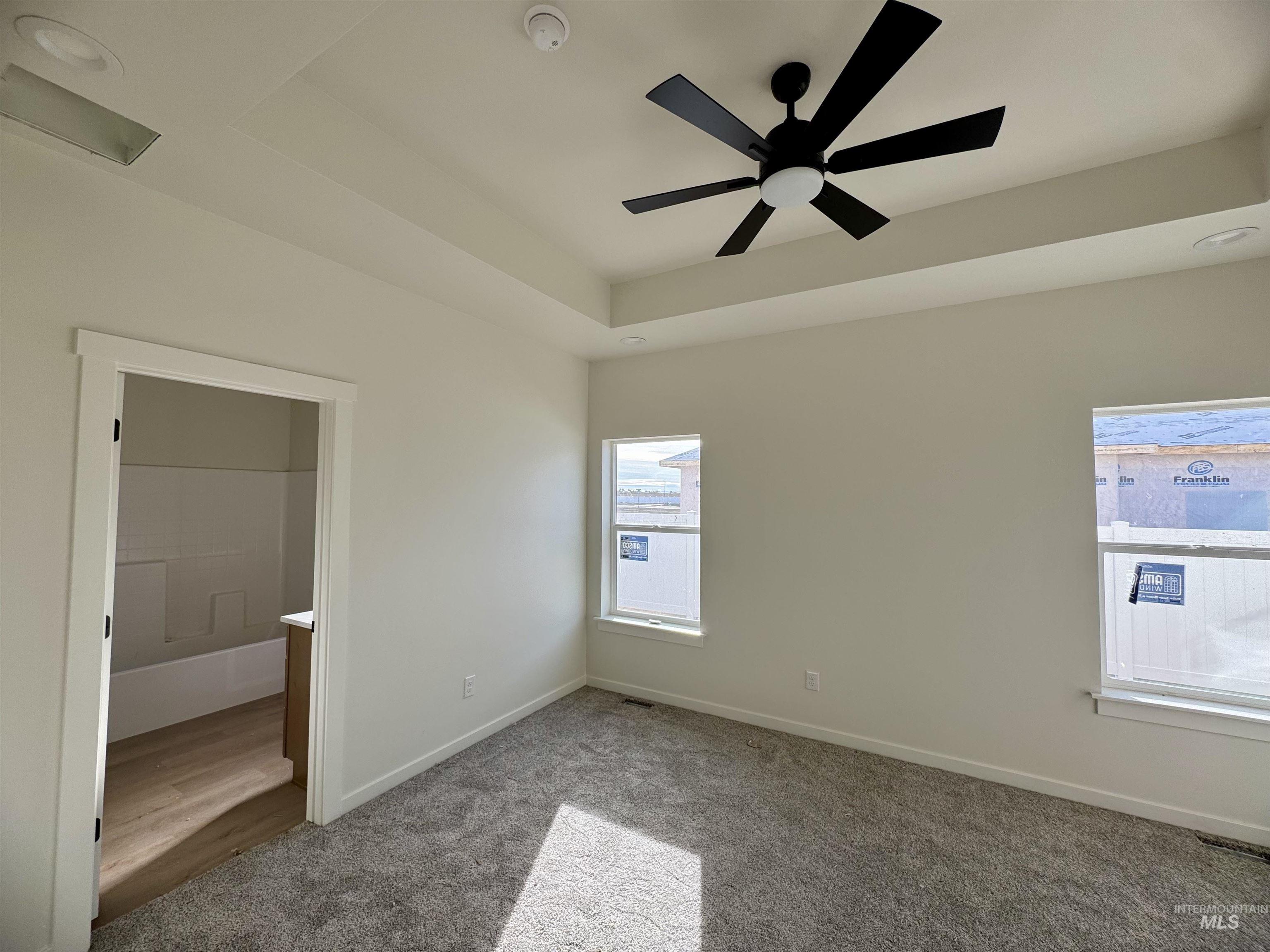 2014 Regan Street Jerome, ID 83338 - Photo 7 of 15 Carpeted empty room with a raised ceiling and a ceiling fan