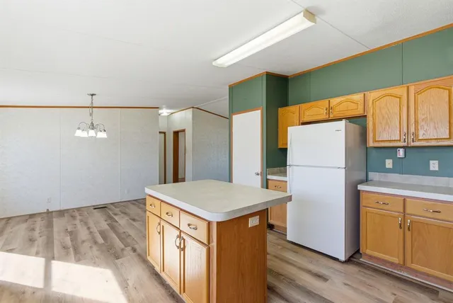 a kitchen with refrigerator cabinets and wooden floor