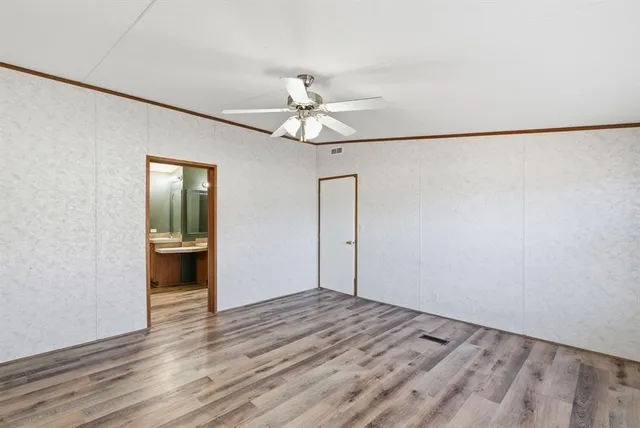 a view of a room with wooden floor and a ceiling fan