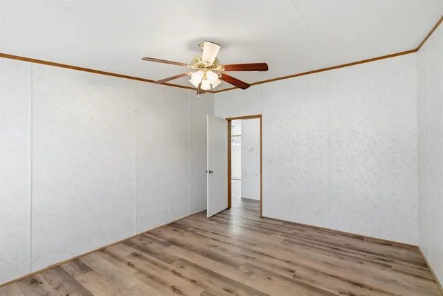 a view of a room with wooden floor and a ceiling fan