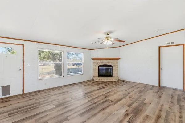 a view of empty room with fireplace and wooden floor