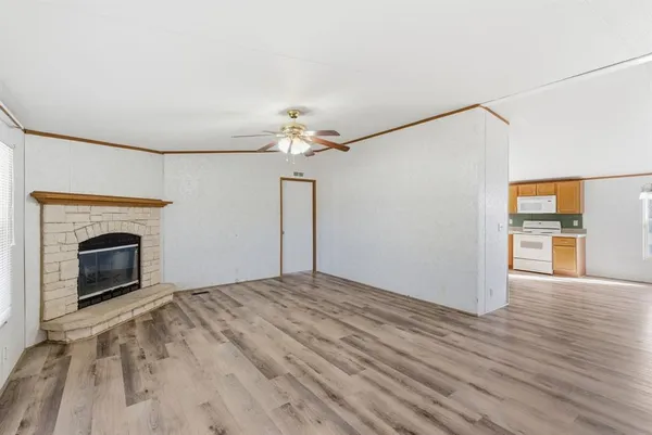 a view of empty room with wooden floor and fireplace