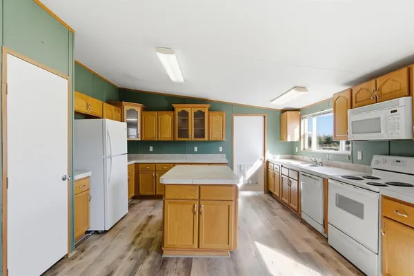 a kitchen with stainless steel appliances a refrigerator a stove top oven and wooden floors