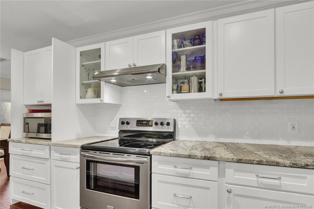 3060 Southeast Darien Road Port St. Lucie, FL 34952 - Photo 11 of 52 a kitchen with stainless steel appliances granite countertop white cabinets and a stove