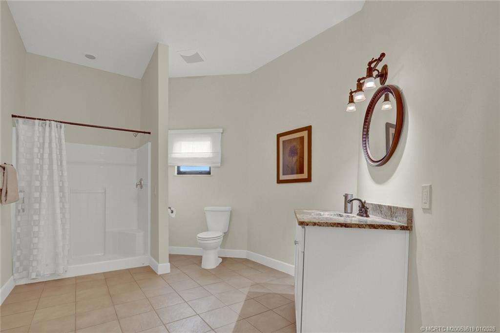 3060 Southeast Darien Road Port St. Lucie, FL 34952 - Photo 30 of 52 a bathroom with a toilet sink and a mirror