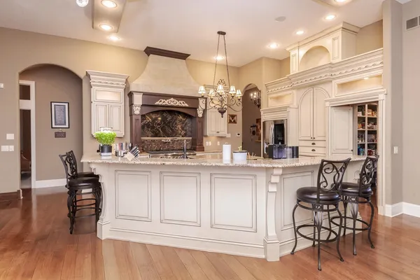 a view of a dining room and livingroom with furniture wooden floor a chandelier