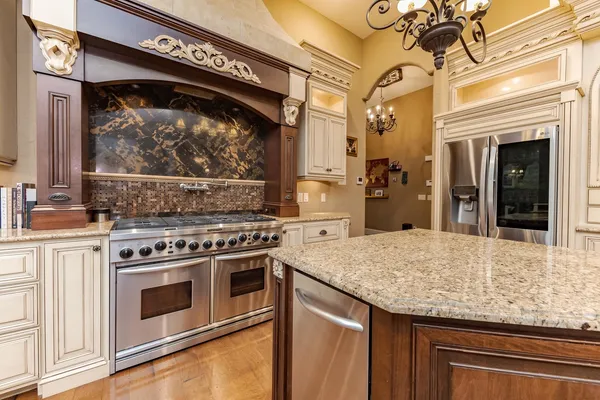 a kitchen with stainless steel appliances granite countertop a stove a sink and a microwave