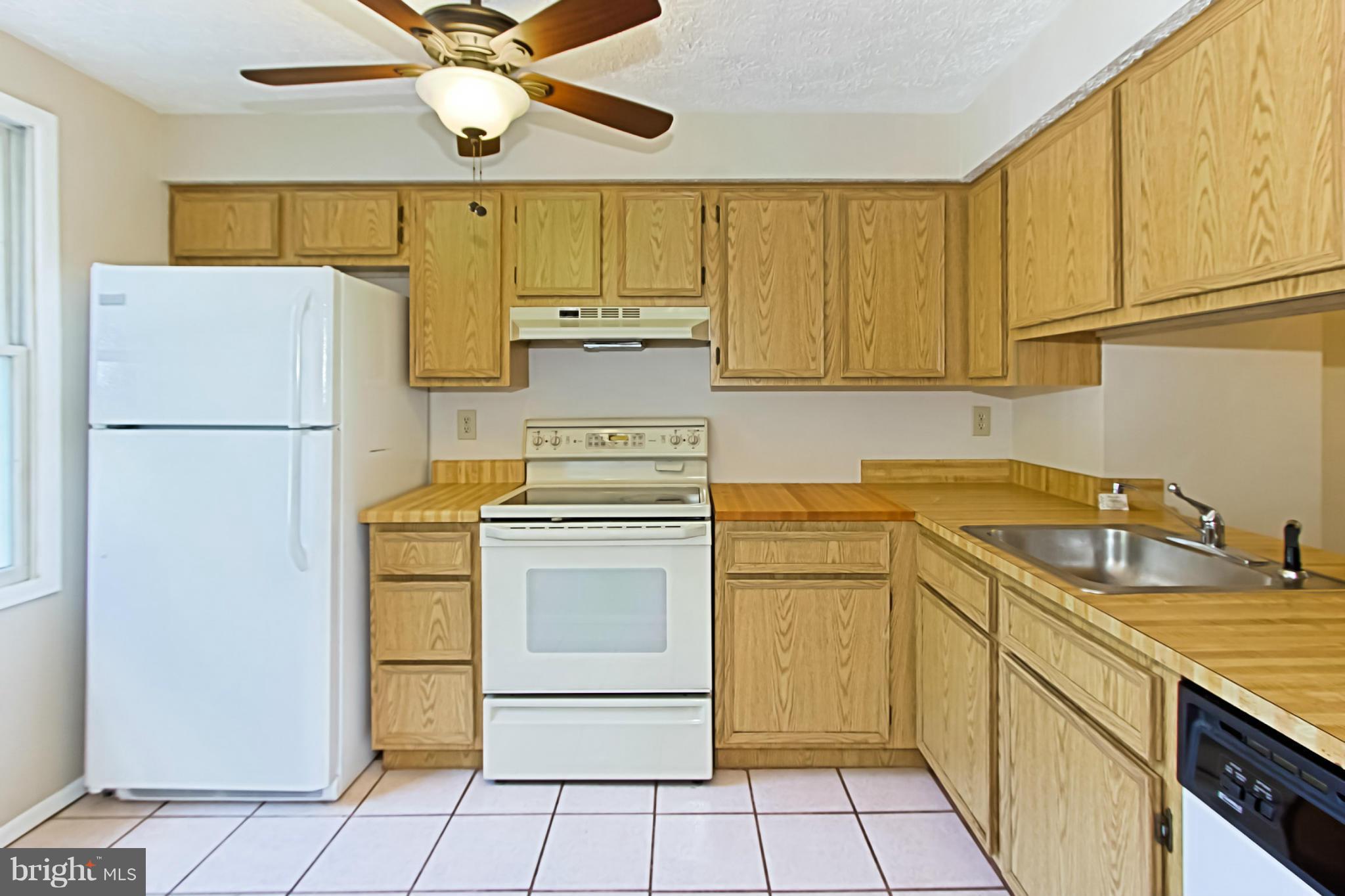 8317 Windfall Road Springfield, VA 22153 - Photo 5 of 19 a kitchen with a refrigerator sink stove and cabinets