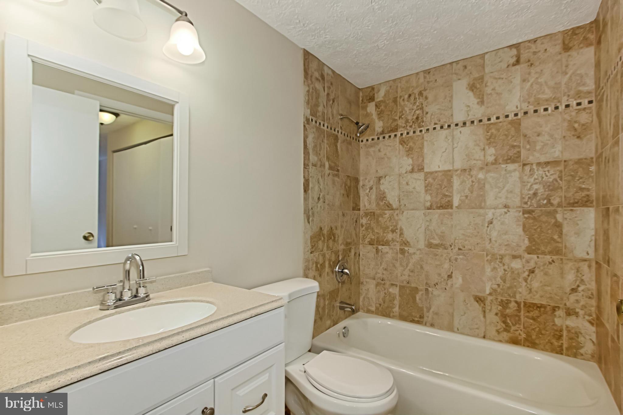 8317 Windfall Road Springfield, VA 22153 - Photo 10 of 19 a bathroom with a granite countertop sink toilet mirror and shower