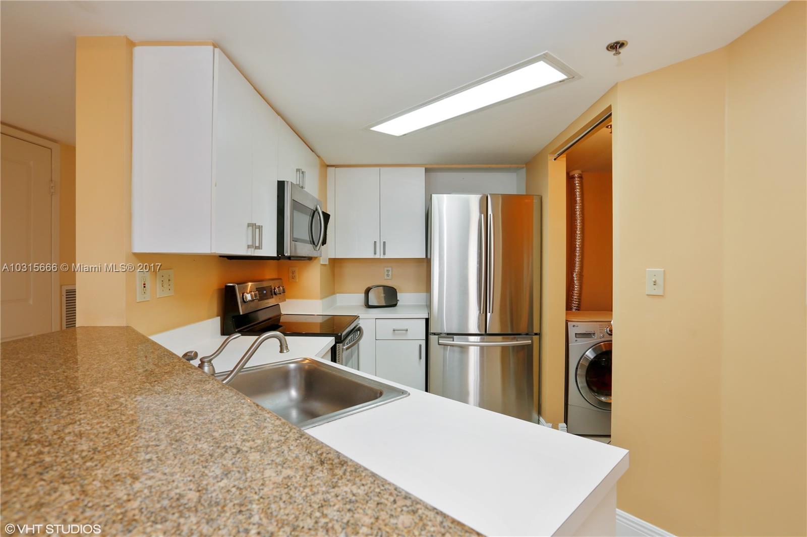 2351 Douglas Road, Unit 1110 Miami, FL 33145 - Photo 1 of 10 a kitchen with a refrigerator and a sink