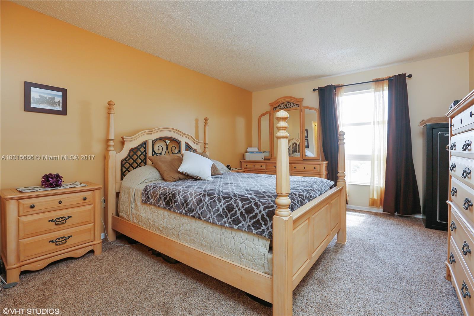 2351 Douglas Road, Unit 1110 Miami, FL 33145 - Photo 4 of 10 a bedroom with a bed a dresser and a window