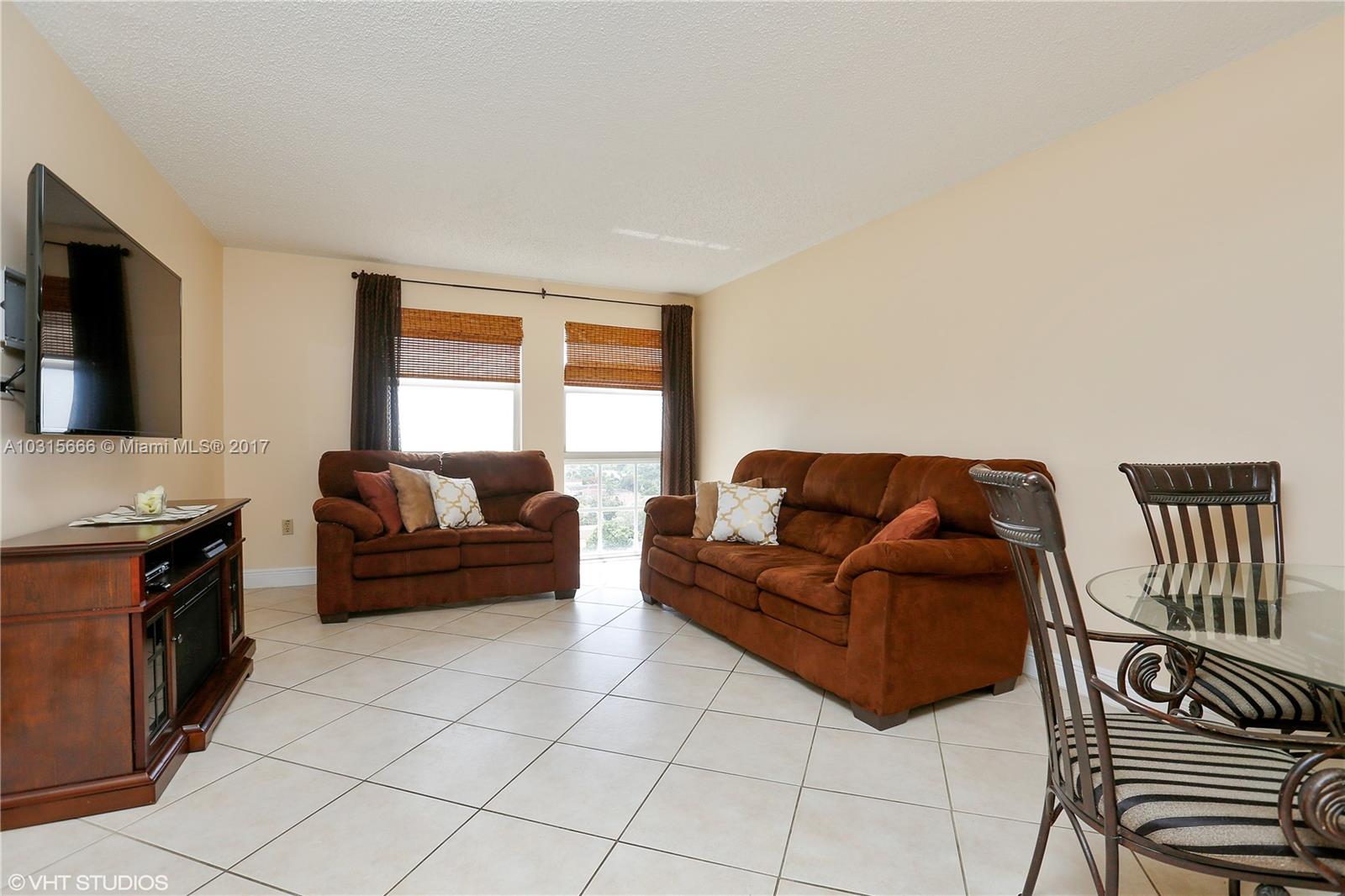 2351 Douglas Road, Unit 1110 Miami, FL 33145 - Photo 5 of 10 a living room with furniture and a flat screen tv