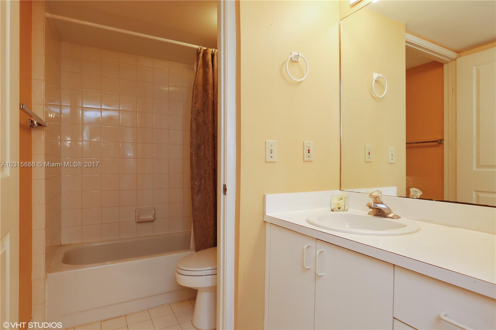 2351 Douglas Road, Unit 1110 Miami, FL 33145 - Photo 6 of 10 a bathroom with a sink a toilet and shower