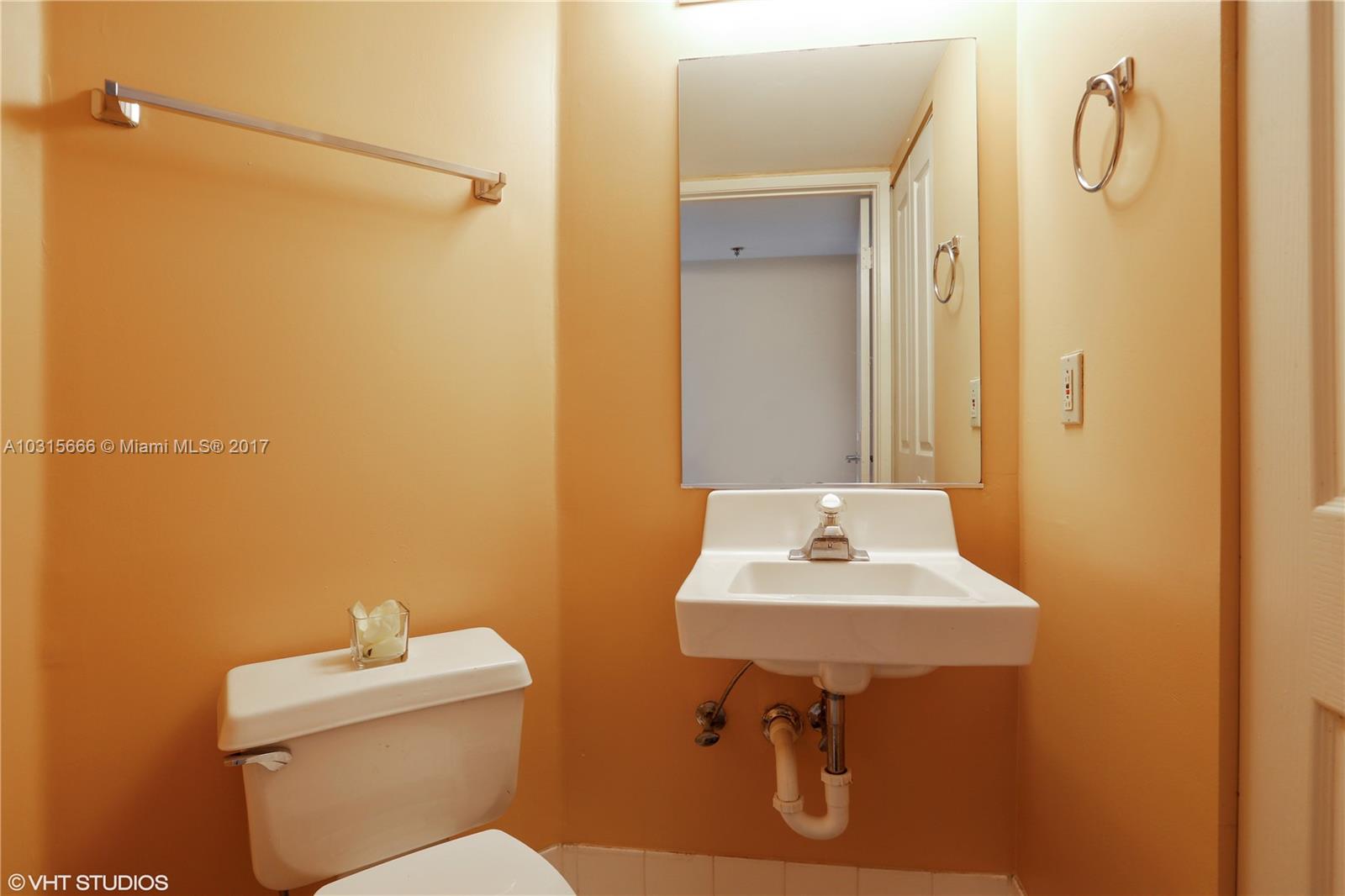 2351 Douglas Road, Unit 1110 Miami, FL 33145 - Photo 7 of 10 a bathroom with a sink a toilet and a mirror