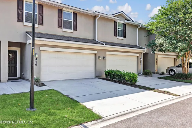 a front view of a house with a yard and a garage