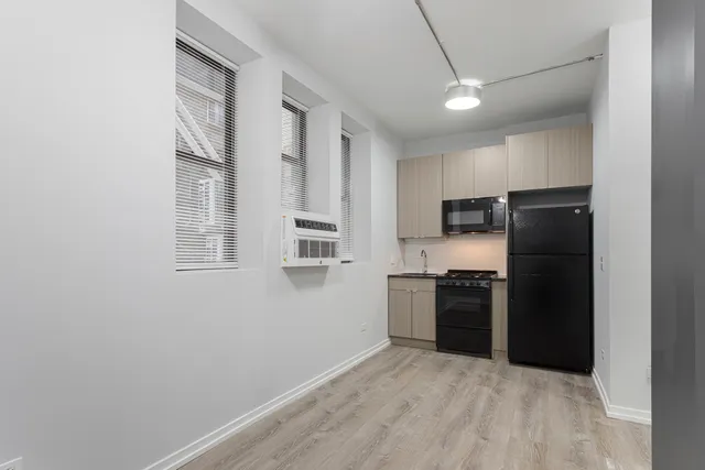 a kitchen with a refrigerator and a stove top oven