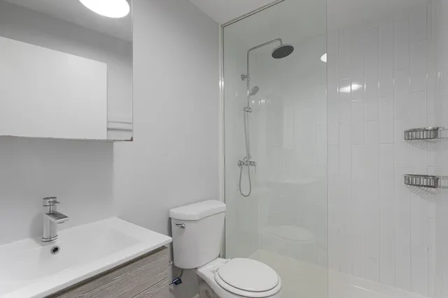 a white toilet sitting next to a bathroom sink