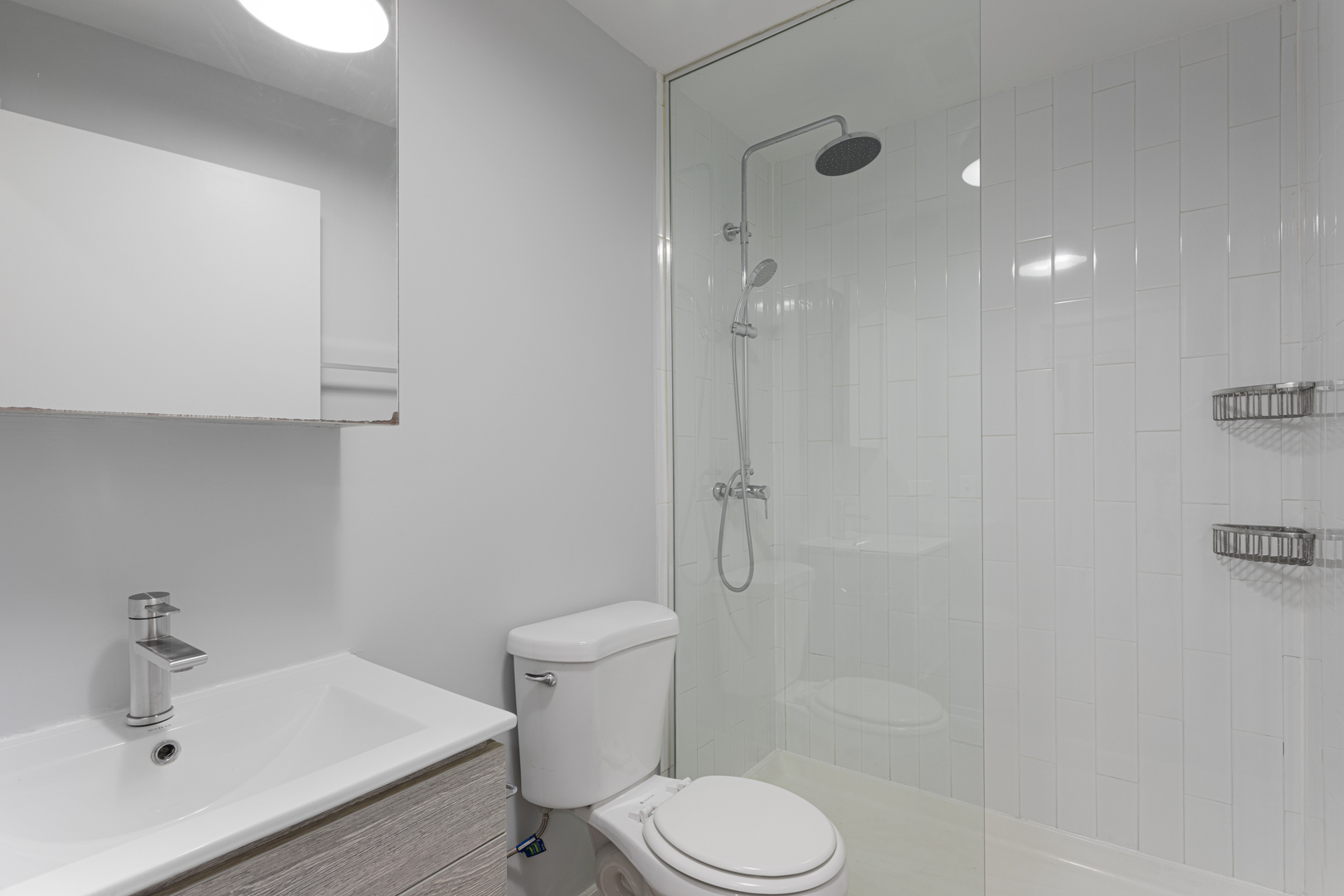 4875 North Magnolia Avenue, Unit 113 Chicago, IL 60640 - Photo 6 of 8 a white toilet sitting next to a bathroom sink