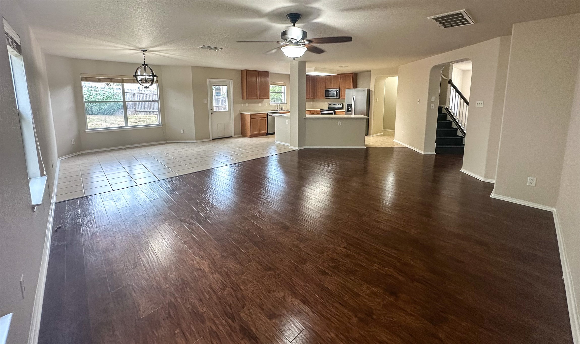 6741 Wayman Ridge San Antonio, TX 78233 - Photo 21 of 21 an empty room with wooden floor a kitchen view and a fireplace