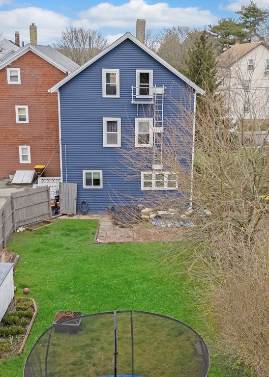 461 Snell Street Fall River, MA 02721 - Photo 3 of 25 a view of a backyard with table and chairs with wooden fence