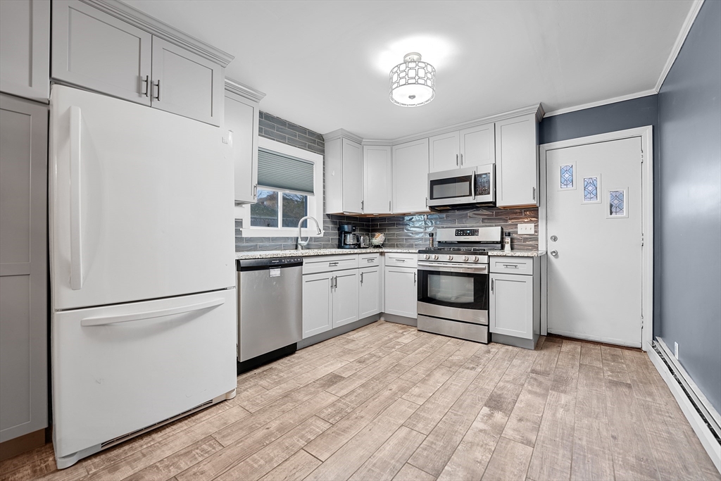 461 Snell Street Fall River, MA 02721 - Photo 7 of 25 a kitchen with white cabinets and stainless steel appliances