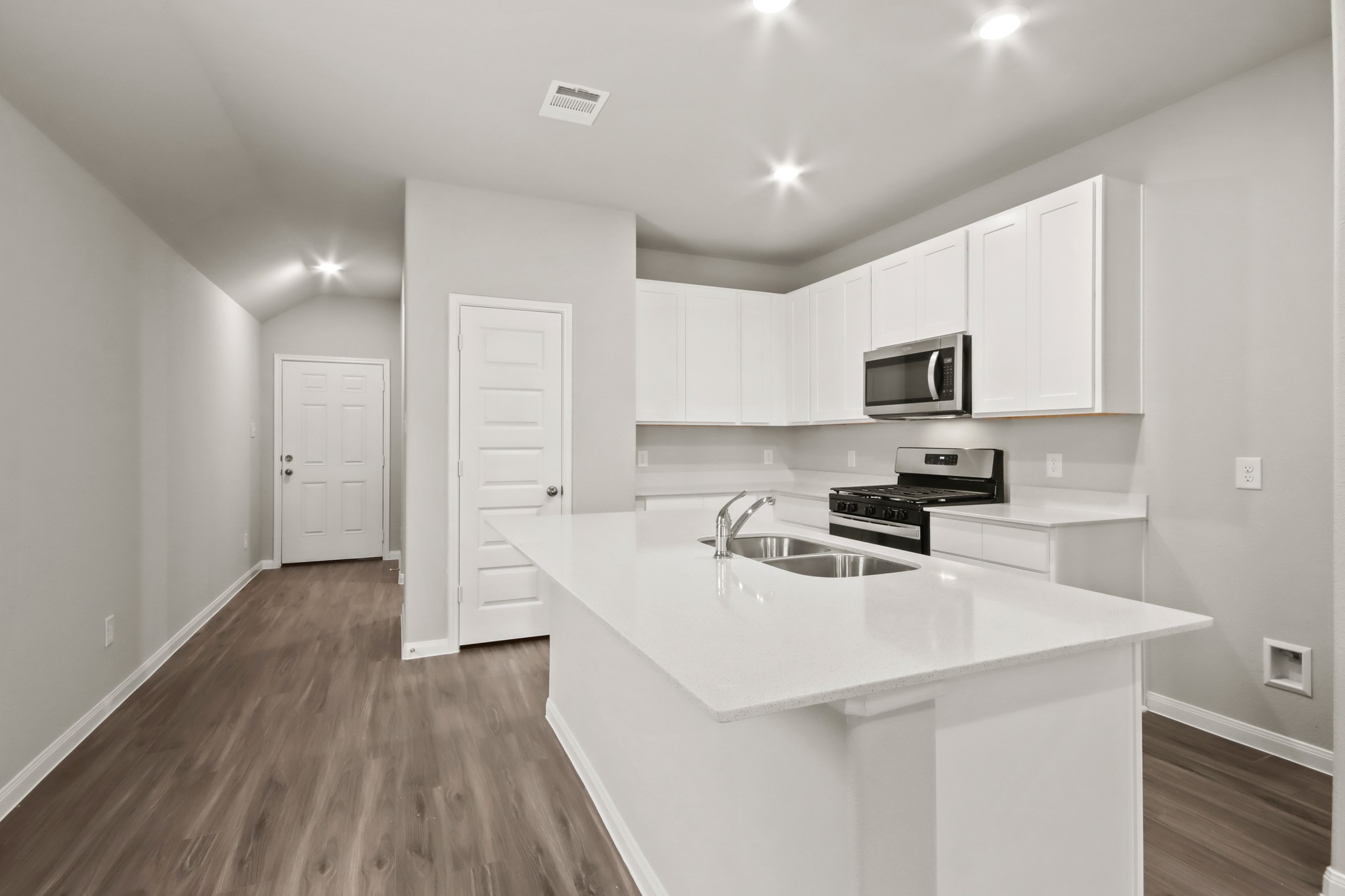 9227 Grace Rdg Drive Willis, TX 77318 - Photo 2 of 23 a kitchen with a sink a stove cabinets and wooden floor