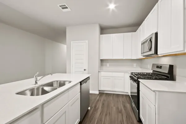 a kitchen with granite countertop a sink a stove and cabinets