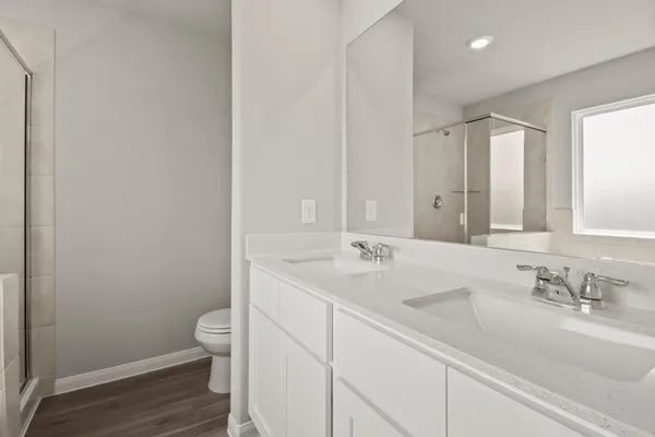 a bathroom with a sink a toilet and a large mirror