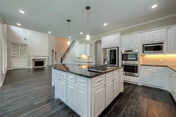 a kitchen with stainless steel appliances granite countertop a stove and a wooden floors