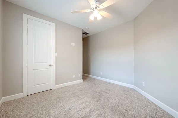 an empty room with a fan and a fan